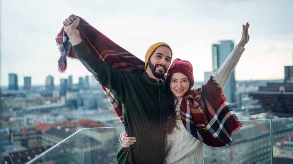 Young couple owners on balcony in new flat, moving in, new home and relocation concept.