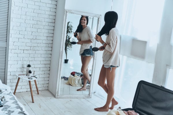 Girl looking in full-length mirror